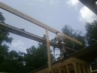 Carpenter setting a ridge beam over a new addition frame — Ice Dam Removal by Roofing Brothers in Long Pond