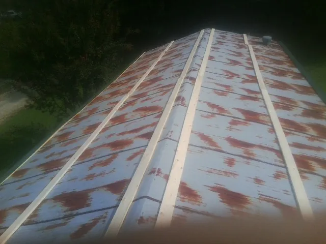 Rusted metal roof panels with new wood purlins before replacement — Storm Damage Roof Repair in Long Pond by Roofing Brothers