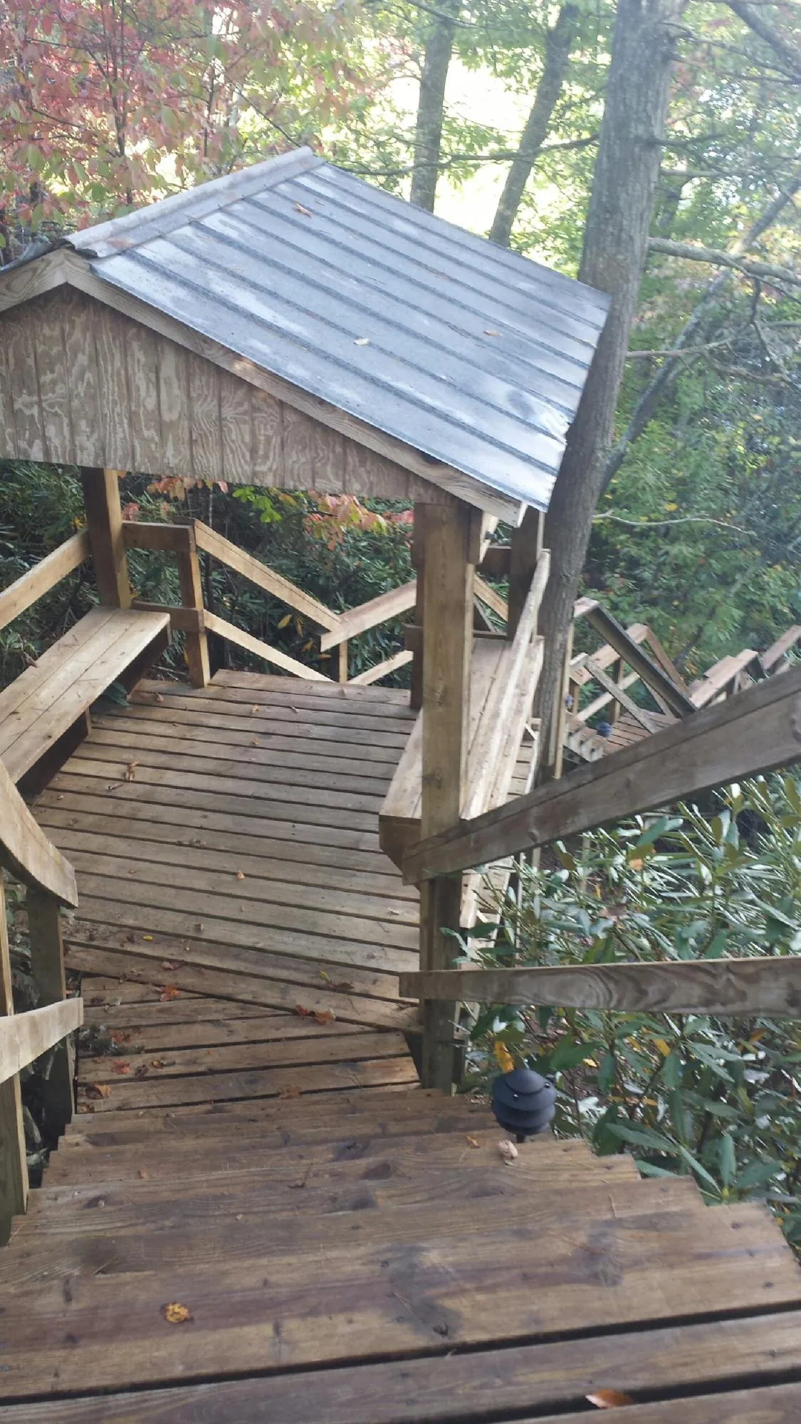 Metal roofed shelter over wooden steps on a wooded walkway — Skylight Repair & Installation work by our crew in Long Pond